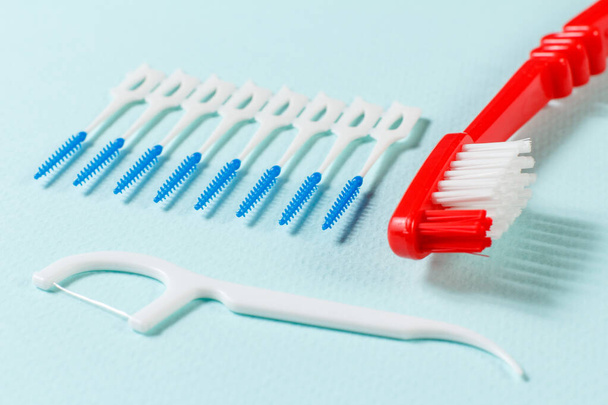 Γκρο πλαν οδοντόβουρτσα και οδοντιατρική οδοντογλυφίδα στο μπλε φόντο - Φωτογραφία, εικόνα