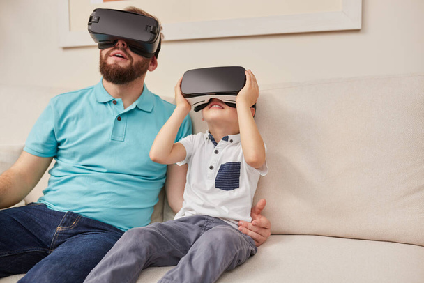 Father and son experiencing cyberspace in VR glasses - Fotoğraf, Görsel