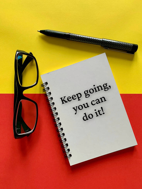 Мотиваційна та натхненна концепція - продовжуйте, ви можете це зробити. З окулярами, ручкою, жовтим і червоним тлом. Мотиваційна концепція
. - Фото, зображення