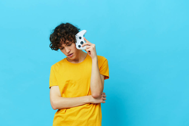 cara encaracolado em fones de ouvido joga jogos gamepad fundos isolados - Foto, Imagem