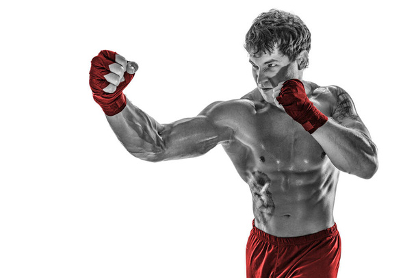 Portrait of boxer who practicing right hook on white background. Black and white. Red sportswear - Photo, Image