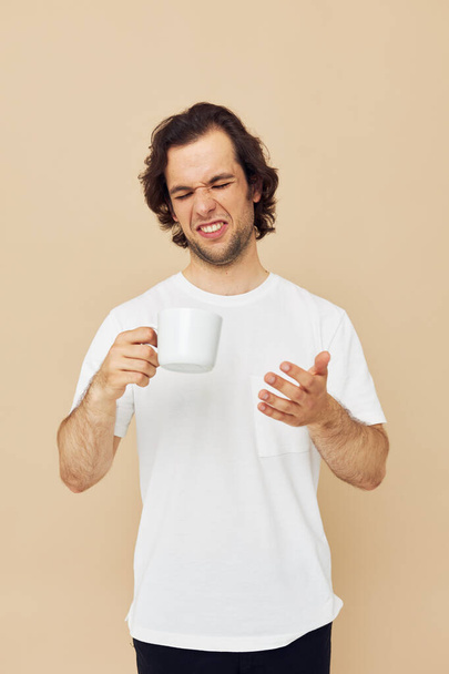 handsome man with a white mug in his hands emotions posing Lifestyle unaltered - Fotoğraf, Görsel