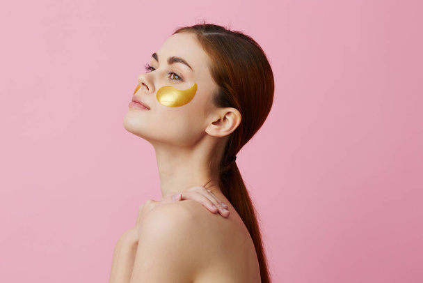 gyönyörű nő bőrápolás arc foltok csupasz vállak higiénia rózsaszín háttér - Fotó, kép