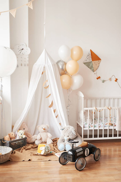 Skandináv stílusú fehér belső gyermekszoba, hálószoba, gyerekszoba. Babaágy lombkoronával. Fa polcok és játékok. Sátor, textil papírsárkány és lufi. - Fotó, kép