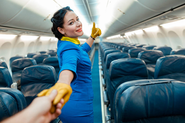 Mulher aeromoça dizendo siga-me em avião de passageiros - Foto, Imagem