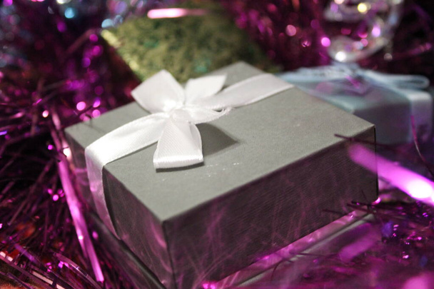ajándékok dobozokban és karácsonyi színes tinsel / fotódobozok ajándékokkal. a tinsel fényes, különböző színekben.ünnepi csillogó ékszerek. - Fotó, kép