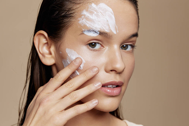 brunette applying a soothing face mask cosmetic isolated background - Φωτογραφία, εικόνα