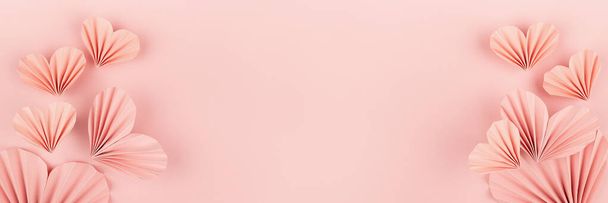 Elegancki miękki różowy papier żebrowany serca w orientalnym stylu origami jako przepływ wzniesień na różowym tle, przestrzeń kopiowania. Delikatne słodkie Walentynki baner na karty, tekst, projekt, reklama. - Zdjęcie, obraz