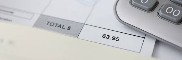 Bienes pagados y calculadora en papel de conteo para pagos basados en el tiempo en la oficina de finanzas de negocios - Foto, Imagen