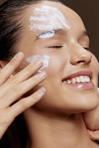 Smiling young woman face mask cream clean skin facial scrub isolated background - Φωτογραφία, εικόνα