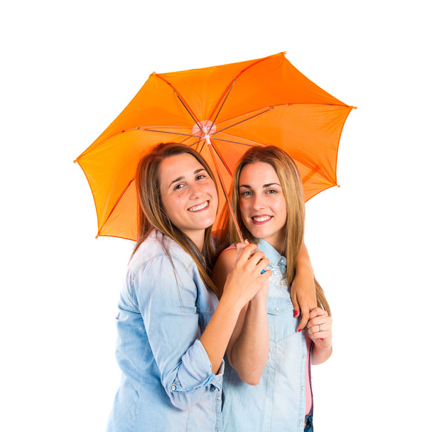 Friends holding an umbrella over white background - Foto, afbeelding