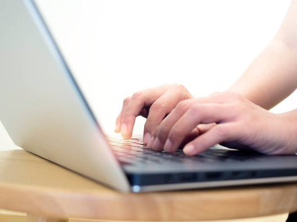 Blisko kobiet ręce wpisując na laptopie klawiatury komputerowej na okrągłym drewnianym stole na białym tle, minimalny styl. Koncepcja biznesu online, praca z technologią, praca w domu, pisanie e-maili. - Zdjęcie, obraz