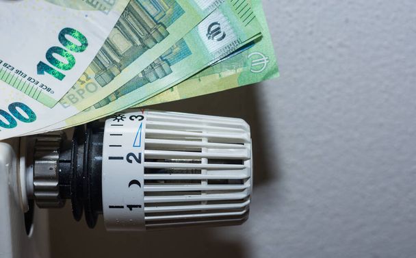 Aumento dos preços da energia e regulador termostático do consumo de energia do aquecimento com muitas notas de 100 euros - Foto, Imagem