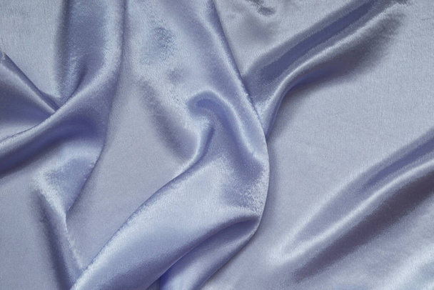Satin, shiny fabric is folded into graceful folds. Grey-blue col - Fotoğraf, Görsel