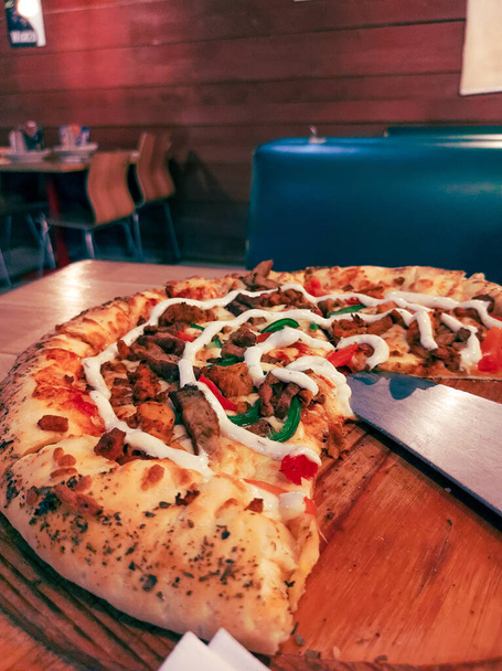 Pizza de crosta recheada servida em mesa de restaurante em pano de fundo de madeira  - Foto, Imagem
