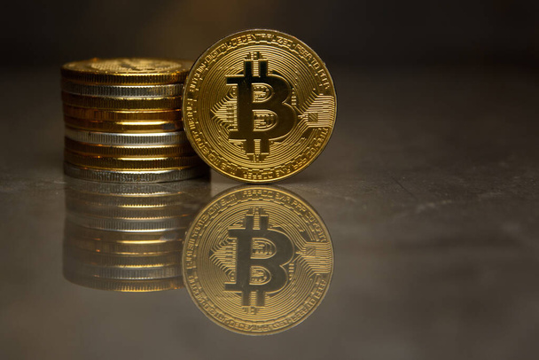  bitcoin de oro y pila de monedas en la superficie reflectante
 - Foto, Imagen