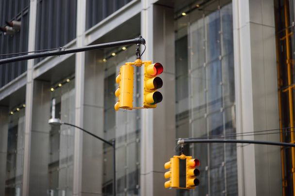 Yellow Traffic Light on background of skyscrapers, Manhattan, New York, USA. Red stop signal. Yellow Traffic Light is one of a characteristic feature of nyc. - Photo, Image