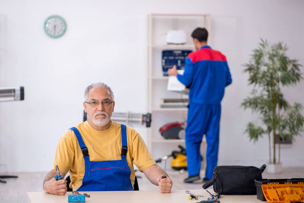 Zwei männliche Reparateure arbeiten in der Werkstatt - Foto, Bild