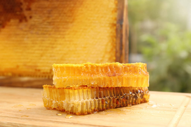 Fresh delicious honeycombs on wooden table outdoors - Φωτογραφία, εικόνα
