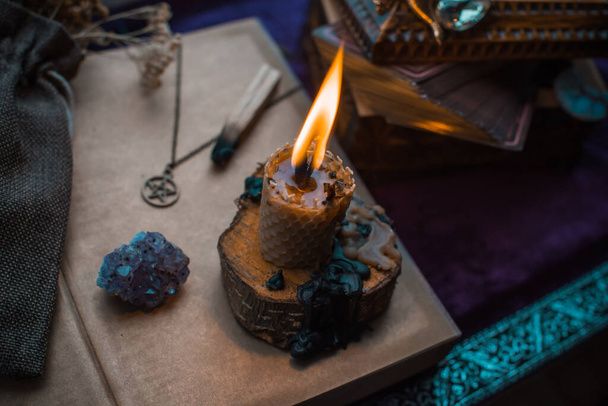 Ilustración para contenidos esotéricos, escena con una vela y libro de hechizos, concepto esotérico, adivinación, otras cosas mágicas sobre una mesa - Foto, Imagen
