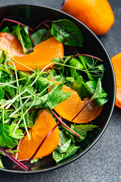 фруктовый салат хурма салат зеленые листья смешать здоровое питание закуски на столе копировать пространство питания фона кето или палео диеты  - Фото, изображение