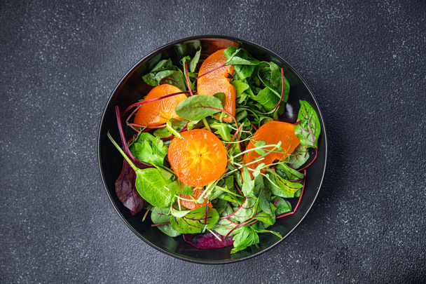 fruitsalade persimmon sla groene bladeren mix gezonde maaltijd voedsel snack op de tafel kopiëren ruimte voedsel achtergrond keto of paleo dieet  - Foto, afbeelding