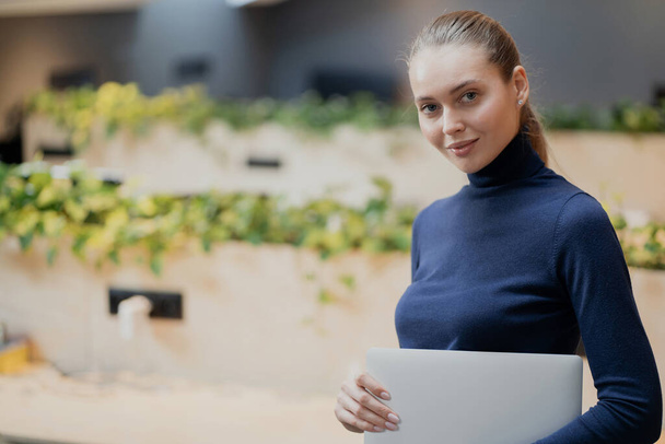 looking at the camera, young confident woman holding a laptop co - Foto, immagini
