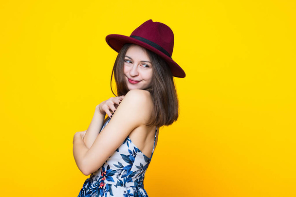 Brunette in a dress and hat on a yellow background - Photo, image