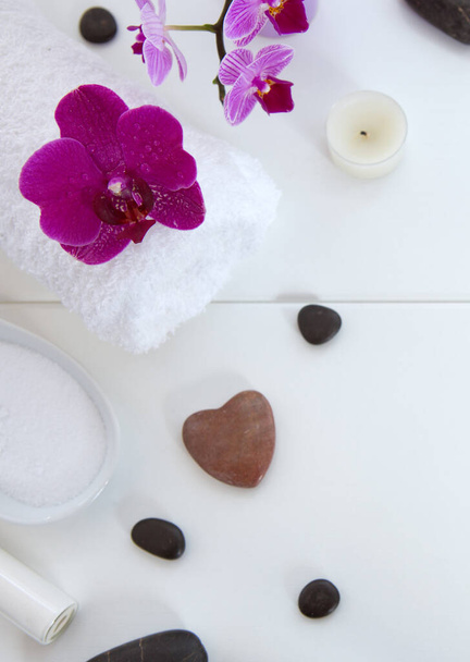 Spa setting with pink orchids, black stones and bath salts on wood background. - Photo, Image