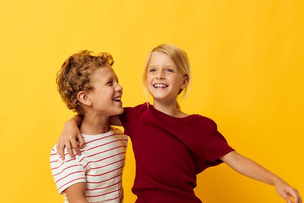 Portrait of cute children cuddling fashion childhood entertainment on colored background - Foto, imagen