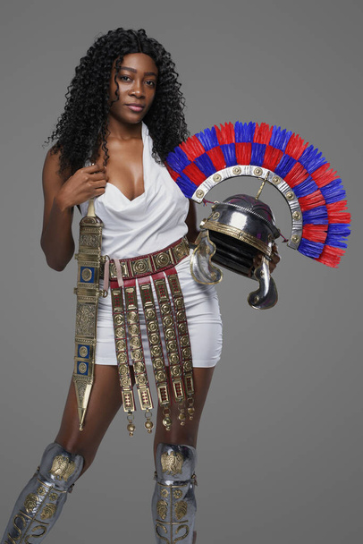 Африканская женщина, держащая шлем на сером фоне - Фото, изображение