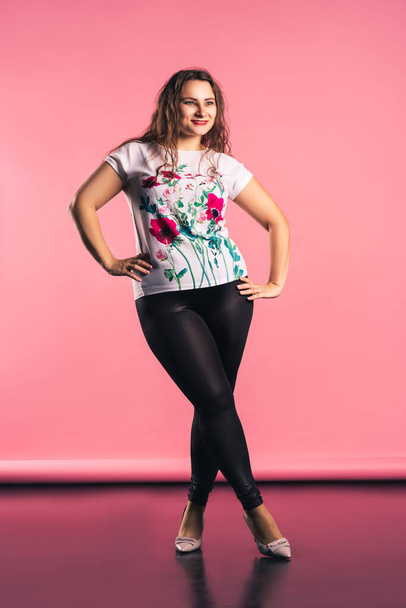Happy plus size model in casual clothes on pink background, body positive concept - Foto, immagini