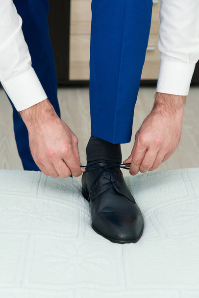 Um jovem amarra os atacadores de seus sapatos detalhe, fokus seletivo - Foto, Imagem