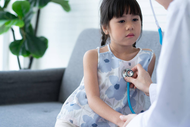 Ázsiai nő gyermekorvos orvos tartja sztetoszkóp vizsgára egy kislány beteg és a nyak szív tüdeje gyerek, Jó család orvos látogató gyermek otthon, Egészségügyi és gyógyszer gyermekkori koncepció. - Fotó, kép