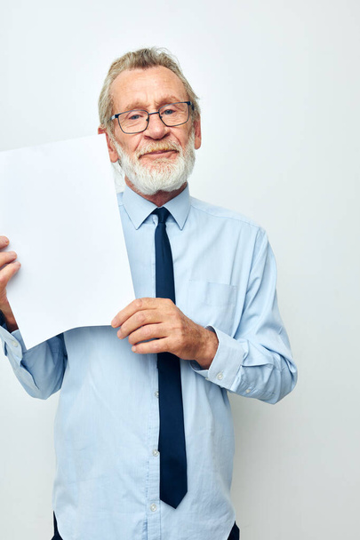 old man holding documents with a sheet of paper light background - Foto, immagini