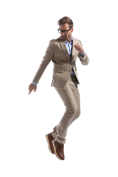 atraente empresário voltar atrás e apontando, vestindo óculos contra fundo branco - Foto, Imagem