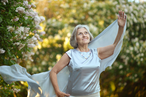 Older woman with white flowers - Фото, зображення