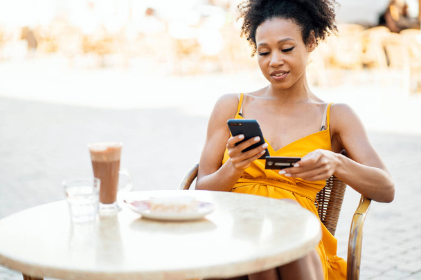 Freelance pays for purchases on the phone in a summer cafe. A female blogger responds to clients in a chat. Manager online work remotely. - Foto, Imagem