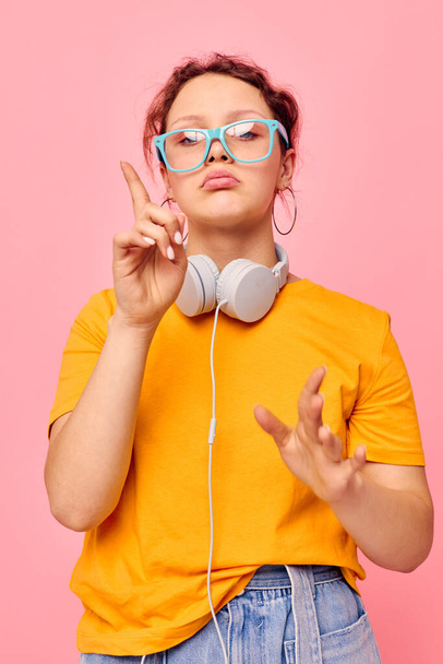portrait of a young woman grimace headphones music entertainment technology pink background unaltered - Fotografie, Obrázek