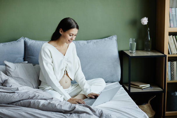Terhes nő használja laptop otthon - Fotó, kép