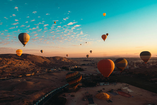 Niesamowity szeroki widok na wiele balonów podczas startu w luxor egypt. Wczesnym rankiem, gdy balony wypełniają niebo - Zdjęcie, obraz