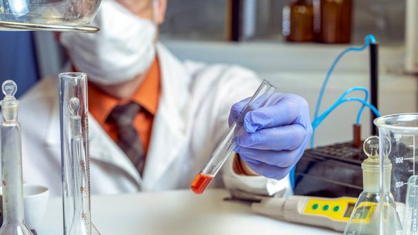 scientists researching in laboratory in white lab coat, gloves analysing, looking at test tubes sample, biotechnology concept. - Фото, зображення