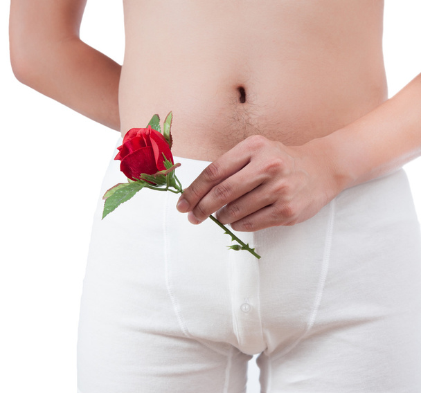Nahaufnahme eines Mannes auf weißer Boxerunterwäsche mit roter Rose - Foto, Bild