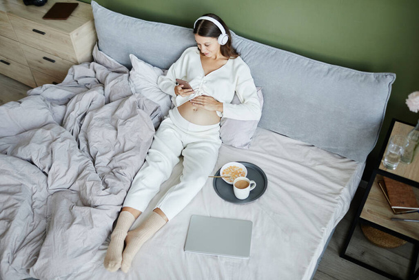 Беременная женщина отдыхает в своей спальне - Фото, изображение