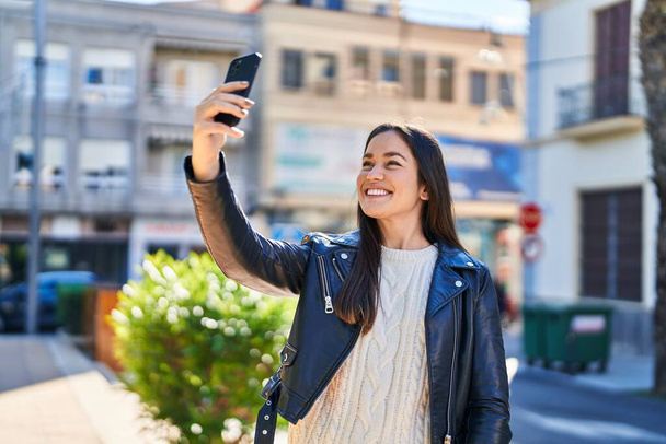 Nuori nainen hymyilee luottavainen tehdä selfie älypuhelimen puistossa - Valokuva, kuva