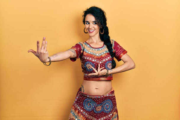 Молодая индианка в традиционном костюме танцора живота. Танцующий экзотический восточный танец с телом и руками - Фото, изображение