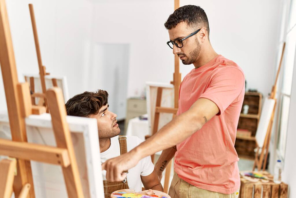 Two hispanic men teacher and student drawing at art studio - Photo, Image