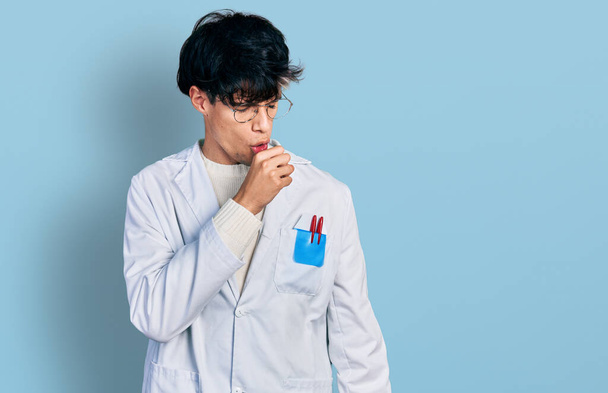 Handsome hipster young man wearing doctor uniform feeling unwell and coughing as symptom for cold or bronchitis. health care concept.  - Фото, зображення