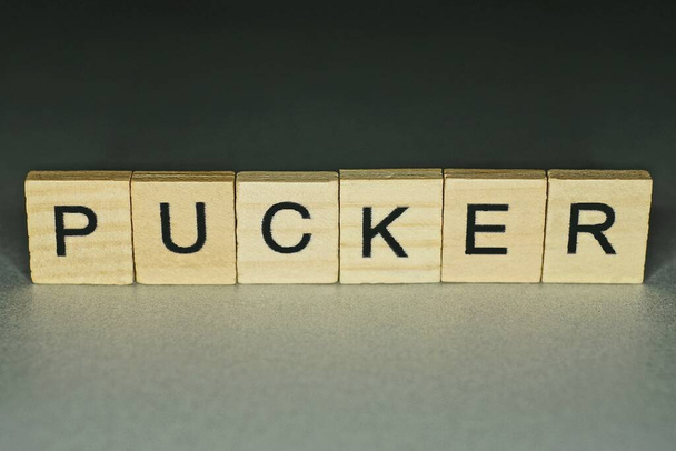 κείμενο σε λέξη pucker από ξύλινα γράμματα σε γκρι φόντο - Φωτογραφία, εικόνα