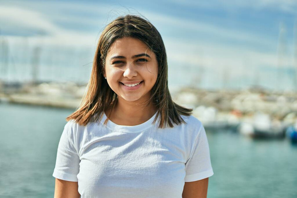 Nuori latino tyttö hymyilee onnellinen seisoo rannalla. - Valokuva, kuva